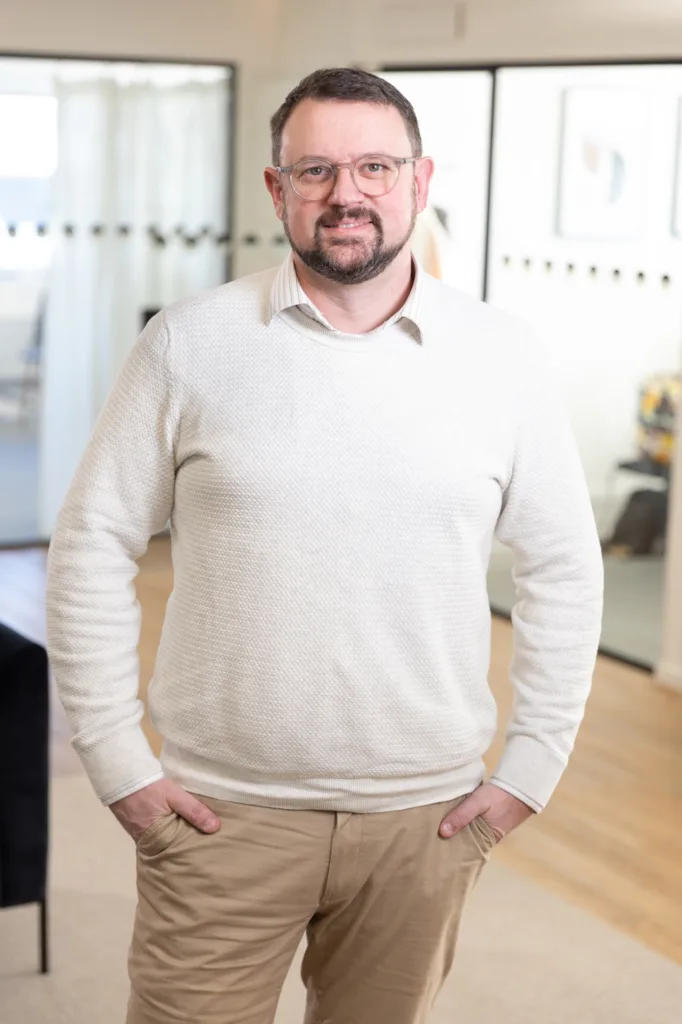 Portrait of a team member, photographed in a professional office environment.