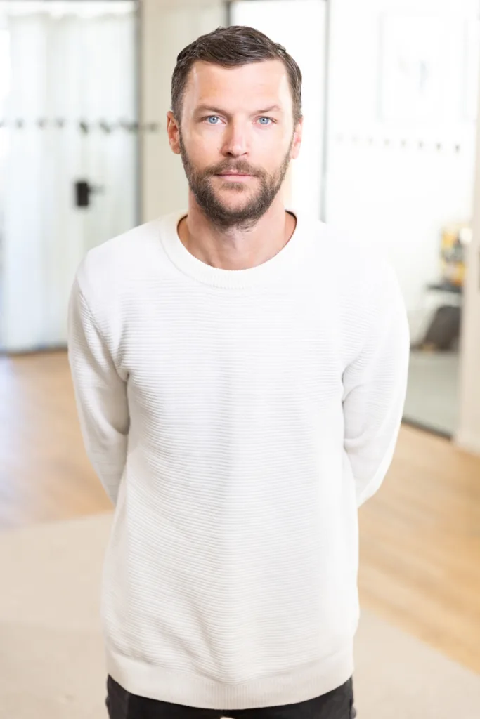 Portrait of a team member, photographed in a professional office environment.